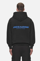 Pegador Colne Logo Oversized Hoodie Washed Black Retro Blue Hauptansicht aus der Never Too Late Kollektion für Herren