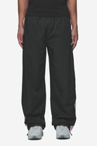 Pegador Stow Wide Track Pants Black Bubblegum Seitenansicht aus der Next Wave Kollektion für Herren